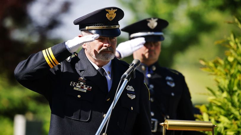 Acting Middletown Police chief Andy Warrick, left, and Det. Connor Kirby salute the flag during a memorial ceremony for fallen officers Thursday, May 16, 2014 at Woodside Cemetery and Arboretum in Middletown. NICK GRAHAM/STAFF