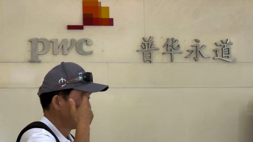 A man walks by the audit firm PricewaterhouseCoopers (PWC) office, at the Fortune Financial Center in Beijing on Tuesday, Aug. 27, 2024. (AP Photo/Andy Wong)