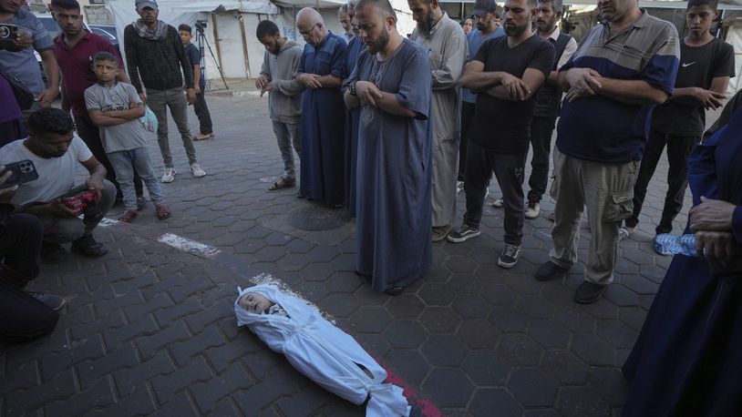 Mourners pray over the body of a Palestinian child, Hosam Al Khaldi, killed in the Israeli bombardment of the Gaza Strip outside the hospital morgue in Deir al-Balah on Wednesday, Oct. 9, 2024. (AP Photo/Abdel Kareem Hana)