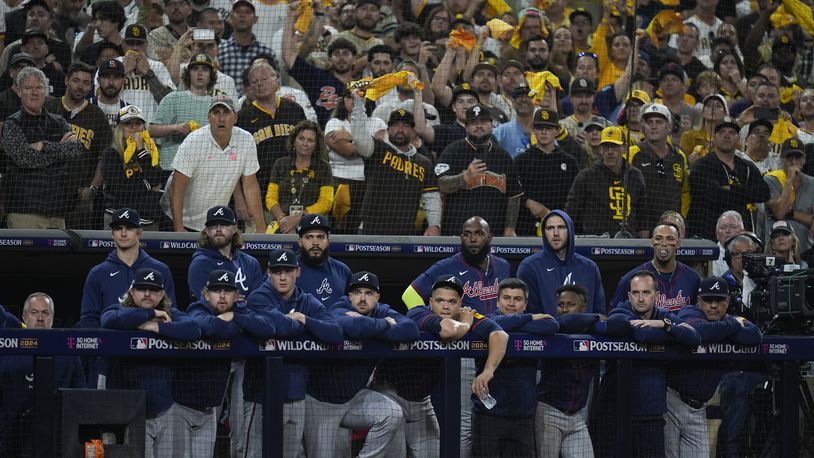 Members to the Atlanta Braves watch from the dugout during the ninth inning in Game 2 of an NL Wild Card Series baseball game against the San Diego Padres, Wednesday, Oct. 2, 2024, in San Diego. (AP Photo/Gregory Bull)