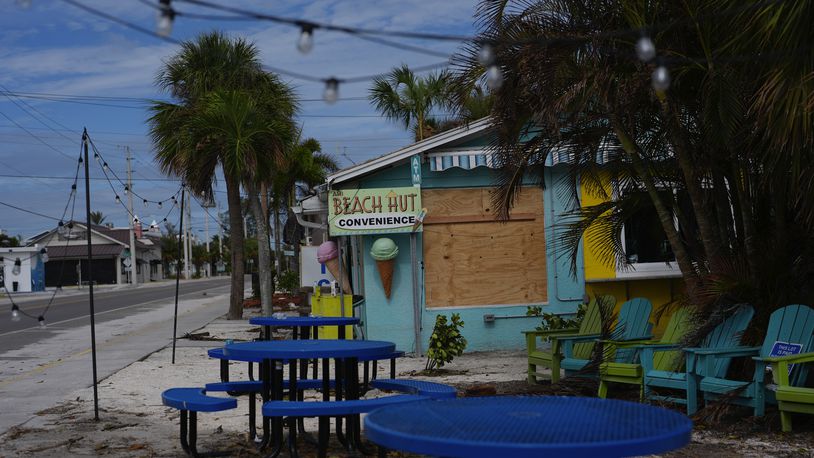 A boarded up business stands beside a deserted street in an evacuation zone, ahead of the arrival of Hurricane Milton, in Anna Maria, Fla., on Anna Maria Island, Tuesday, Oct. 8, 2024. (AP Photo/Rebecca Blackwell)