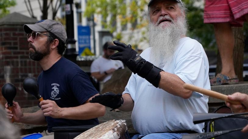 Mel McDonald plays music at a drum circle Friday, Oct. 4, 2024 in Asheville, N.C., a week after Hurricane Helene upended lives across the Southeast. (AP Photo/Brittany Peterson)