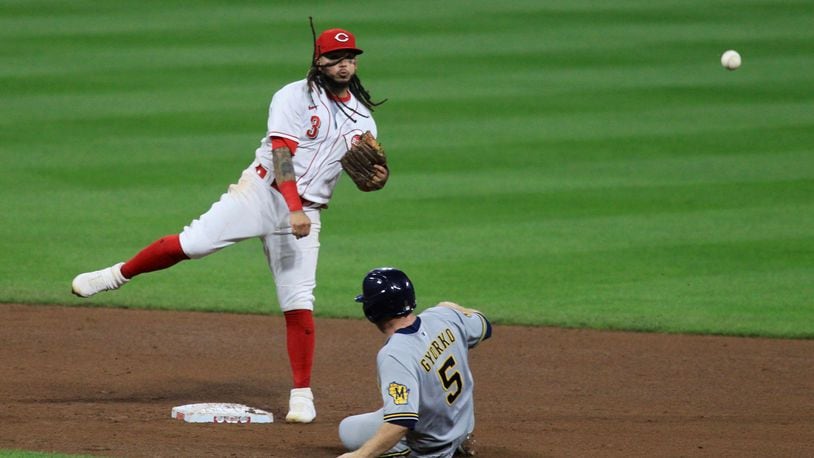 Reds second baseman Freddy Galvis turns a game-ending double play against the Brewers on Wednesday, Sept. 23, 2020, at Great American Ball Park in Cincinnati. David Jablonski/Staff