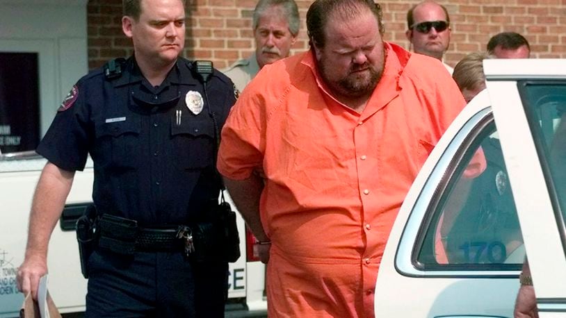 FILE - Officials escort murder suspect Alan Eugene Miller away from the Pelham City Jail in Alabama, Aug. 5, 1999. (AP Photo/Dave Martin, File)