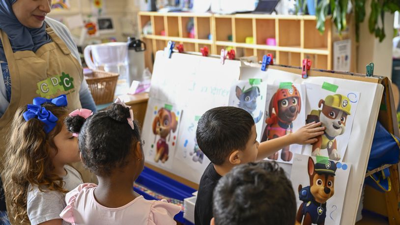 Preschool teacher Tinhinane Meziane, left, listens to her students on what characters of the TV show PAW Patrol they will vote for as their favorite character at the ACCA Child Development Center, Thursday, Sept. 19, 2024, in Annandale, Va. The students are getting foundational lessons on how to live in a democracy by allowing them to regularly vote on different things through out the day. (AP Photo/John McDonnell)