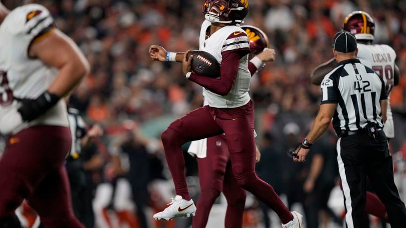 Washington Commanders quarterback Jayden Daniels celebrates after throwing a touchdown pass during the second half of an NFL football game against the Cincinnati Bengals, Monday, Sept. 23, 2024, in Cincinnati. (AP Photo/Carolyn Kaster)