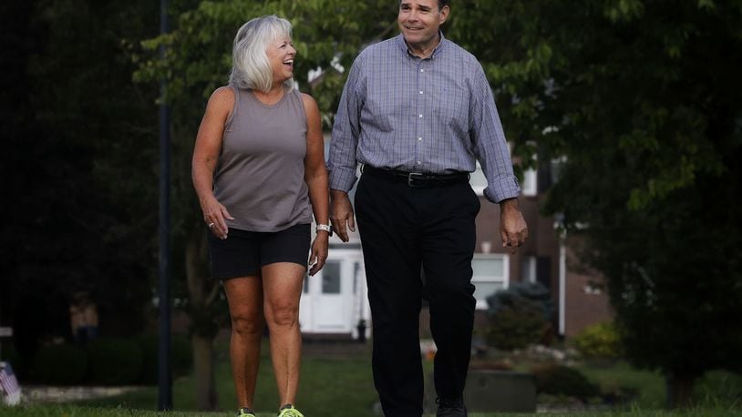 After a heart attack, Ray Bange walks with his wife, Peggy, as part of his rehabilitation in their neighborhood in Hamilton. NICK GRAHAM/STAFF