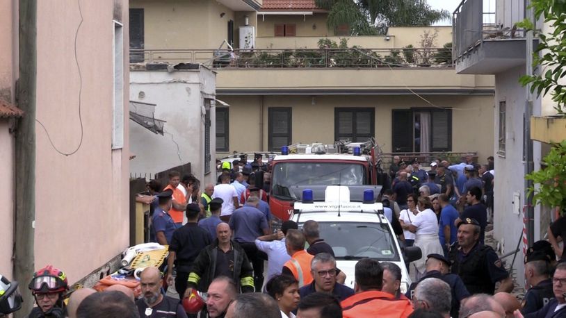 Emergency services attend the site of a building collapse in Saviano, Italy, Sunday Sept, 22, 2024. (LaPresse via AP)