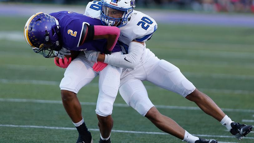 Butler's Tayven Crump is tackled by Xenia's Trimonde Henry after catching a pass. BILL LACKEY/STAFF