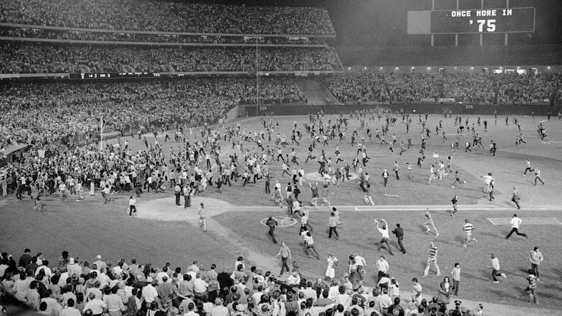 FILE - Fans pour onto the field at the Oakland Coliseum after the Oakland A's beat the Los Angeles Dodgers 3-2 and won their third straight World Series, Oct. 17, 1974, in Oakland. (AP Photo, File)