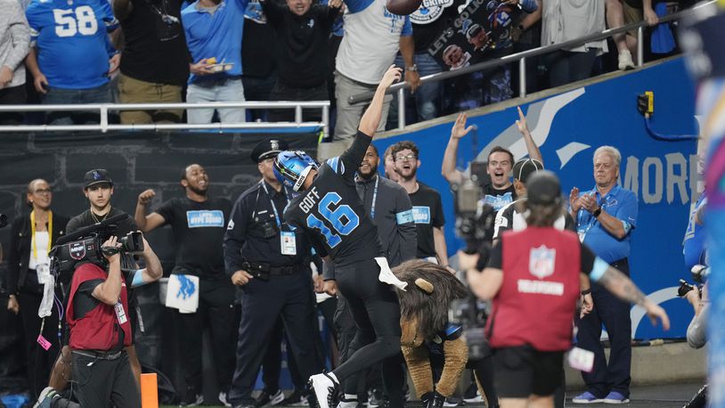 Detroit Lions quarterback Jared Goff tosses the football into the stands after his rushing touchdown during the second half of an NFL football game against the Seattle Seahawks, Monday, Sept. 30, 2024, in Detroit. (AP Photo/Paul Sancya)