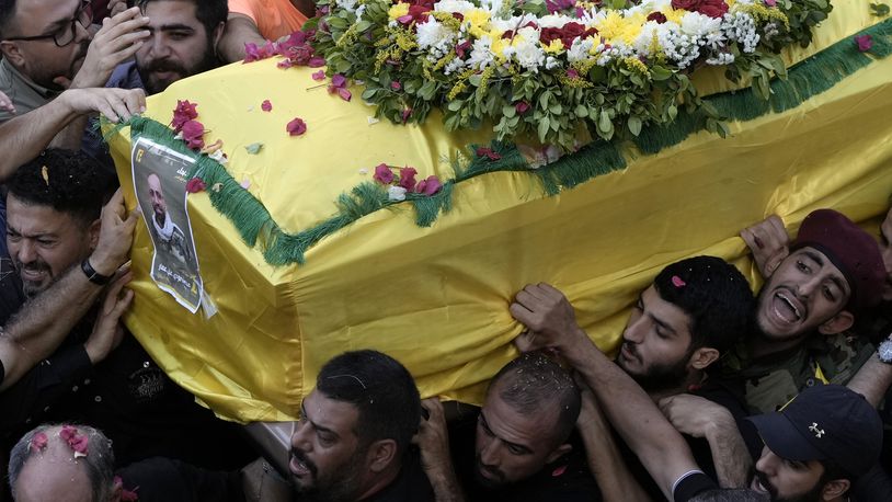 FILE - Hezbollah fighters carry one of the coffins of four fallen comrades who were killed Tuesday after their handheld pagers exploded, in the southern suburb of Beirut, Wednesday, Sept. 18, 2024. (AP Photo/Bilal Hussein, File)