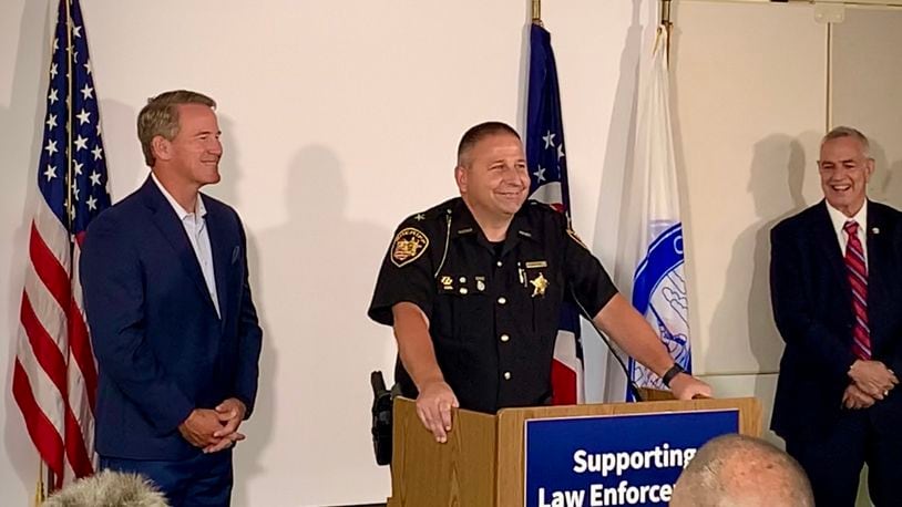 Lieutenant Governor Jon Husted (left) and Montgomery County Sheriff Rob Streck (center) speak during Ohio Means Jobs announcement of its Law Enforcement Career portal, aimed at better connecting applicants with police departments in need of workers. LONDON BISHOP/STAFF