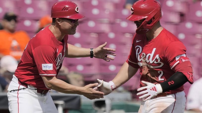 Cincinnati Reds' Ty France, right, celebrates with third base coach J.R. House as he rounds the bases after hitting a home run during the seventh inning of a baseball game against the Houston Astros, Thursday, Sept. 5, 2024, in Cincinnati. (AP Photo/Carolyn Kaster)