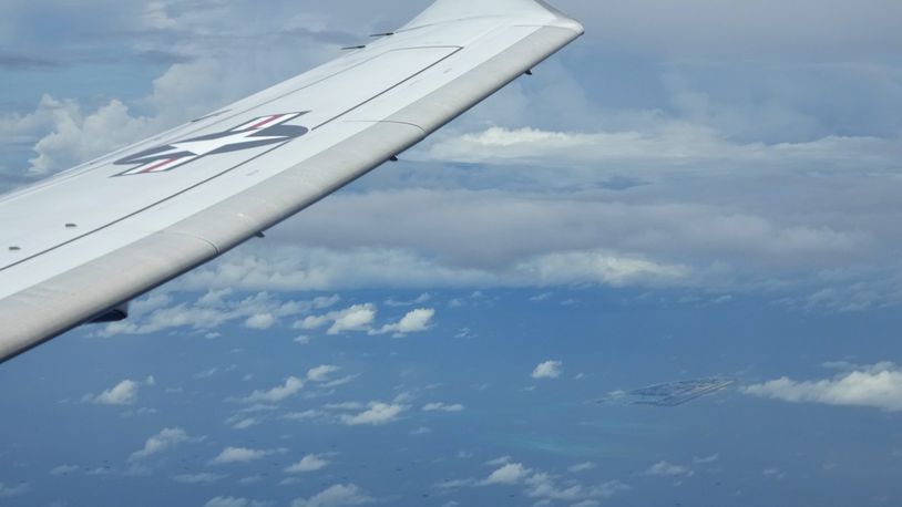 FILE - A U.S. P-8A Poseidon reconnaissance plane flies near Chinese structures and buildings on the man-made Fiery Cross Reef at the Spratlys group of islands in the South China Sea are seen on March 20, 2022. (AP Photo/Aaron Favila, File)