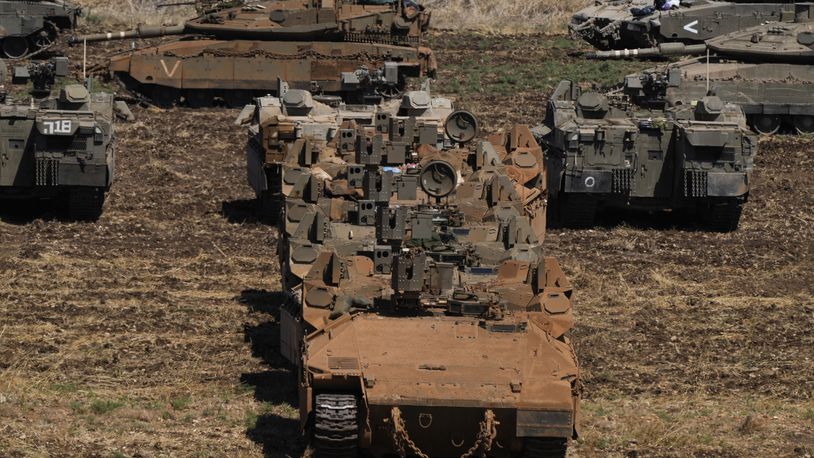 Israeli soldiers work on tanks and APC in northern Israel on Friday, Sept. 27, 2024. (AP Photo/Baz Ratner)