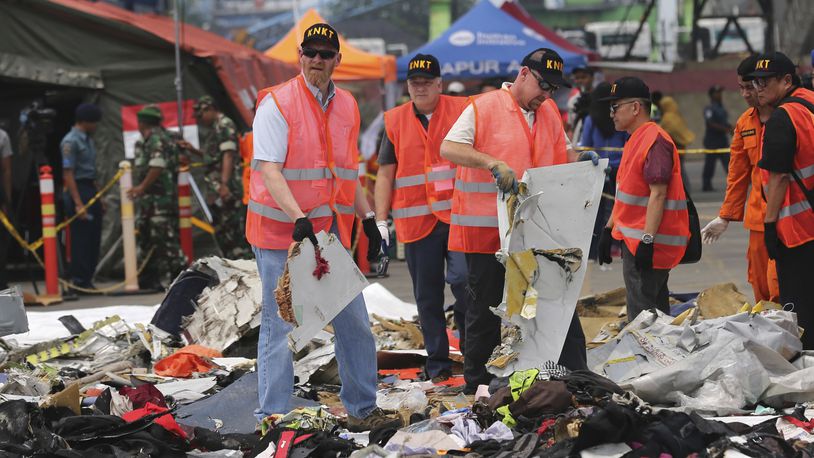 U.S. investigators examine parts on recovered from the crash of a Lion Air jet at Tanjung Priok Port in Jakarta, Indonesia, Nov. 1, 2018. Lion Air flight 610, a Boeing 737 Max, crashed minutes after takeoff on Oct. 29, 2018. U.S. prosecutors and victims' families are waiting for Boeing to decide whether to accept a plea deal that would settle a criminal charge that the aerospace giant misled regulators who approved the 737 Max before two of the jetliners crashed in Indonesia and Ethiopia. (AP Photo/Tatan Syuflana, File)