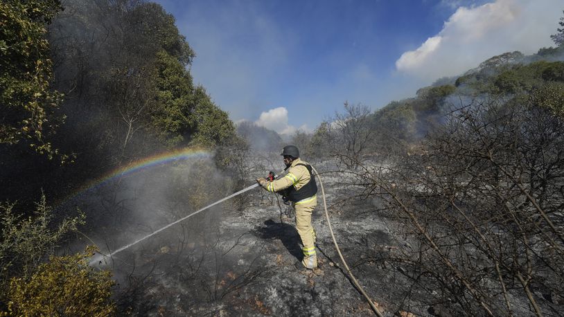 An Israeli firefighter works to extinguish a fire after a rocket fired from Lebanon hit an open field in northern Israel, Wednesday, Sept. 18, 2024. (AP Photo/Baz Ratner)