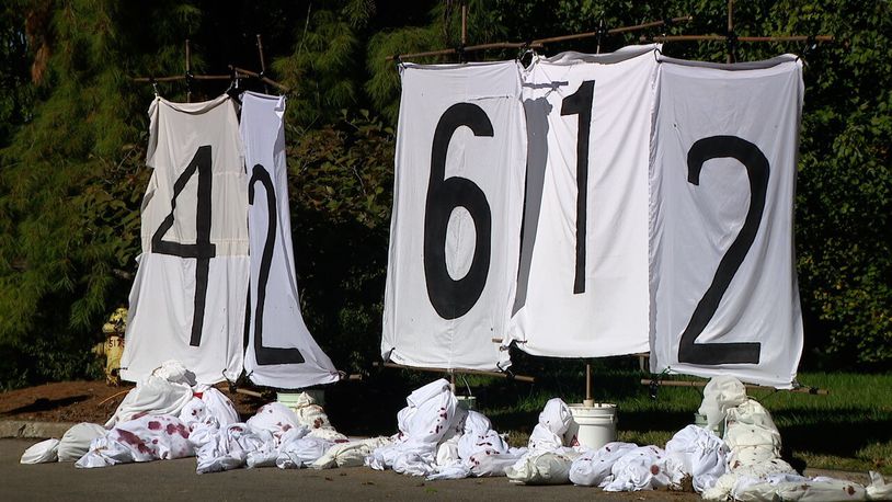 Protesters painted the death toll in Gaza on bed sheets and placed it above body bags outside of Rep. Greg Landsman’s Cincinnati home. WCPO