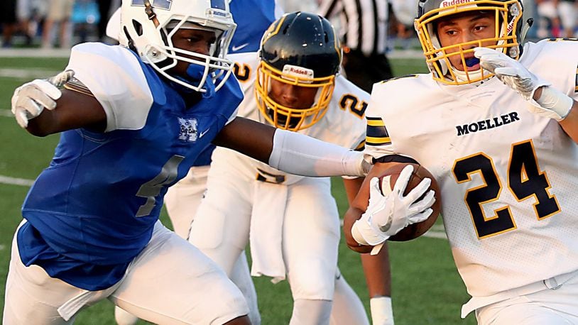 Hamilton’s Deon Tillery stops Moeller’s R.J. Khayo during their Skyline Chili Crosstown Showdown game at Virgil Schwarm Stadium in Hamilton last Saturday. The visiting Crusaders won 42-7. CONTRIBUTED PHOTO BY E.L. HUBBARD