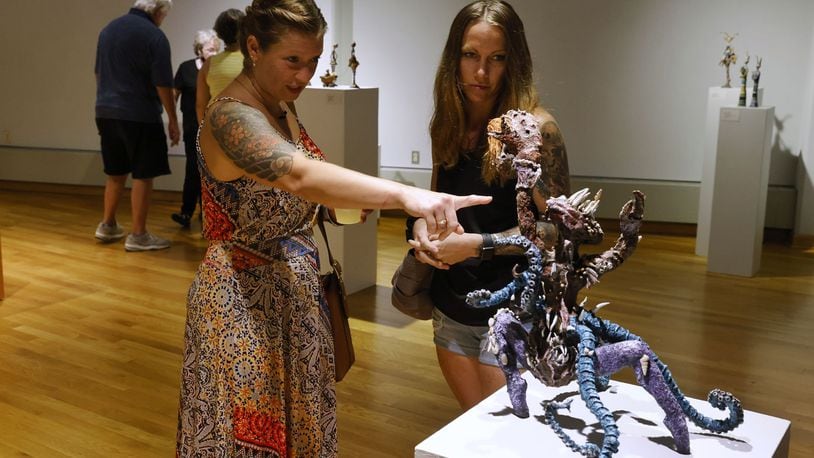 Casey Madore, left, and Ashley Reed look at sculptures creatiled by Madore's mom, Pamela Hignite, at the Fitton Center for Creative Arts launch event with live music, dance and art demonstrations, art exhibits and more to kick off their 2022-2023 season Friday, Aug. 19, 2022 in Hamilton. NICK GRAHAM/STAFF
