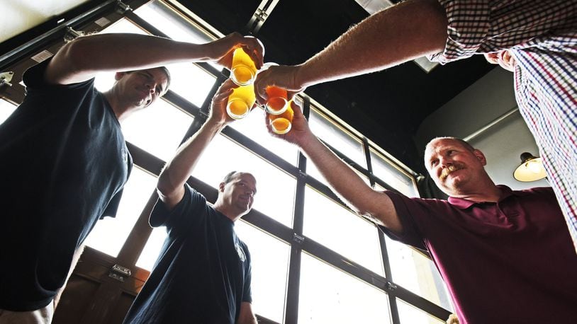 For the third time, Hamilton’s Municipal Brew Works again will tap its special Woltermelon Blonde Ale to honor fallen firefighter Patrick Wolterman. A ceremonial first pour and toast is set for Aug. 2. Pictured are friends are family of Wolterman during the beer’s 2016 limited release. NICK GRAHAM/FILE (2016)