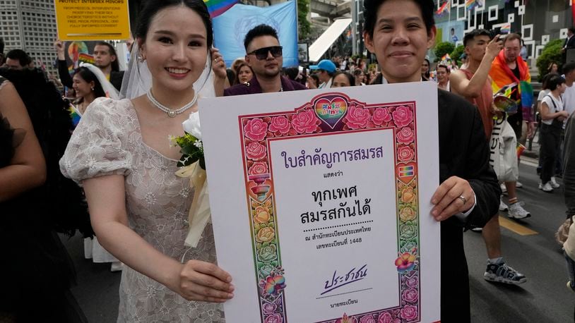 FILE - Participants hold posters celebrating equality in marriage during the Pride Parade in Bangkok, Thailand, Saturday, June 1, 2024. (AP Photo/Sakchai Lalit, File)