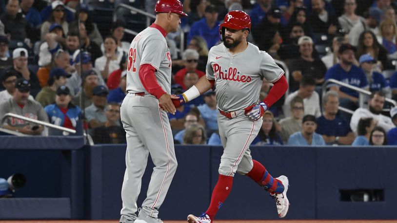 Philadelphia Phillies' Kyle Schwarber, right, celebrates with third base coach Dusty Wathan after hitting a solo home run in the fourth inning of a baseball game against the Toronto Blue Jays in Toronto on Tuesday Sept. 3, 2024. (Jon Blacker/The Canadian Press via AP)