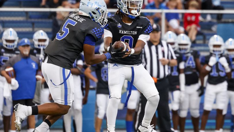 Hamilton's Gracen Goldsmith (5) takes a handoff from quarterback Antonio Mathis during their football game Friday, Sept. 6, 2024 at Hamilton's Virgil M. Schwarm Stadium. Lakota East won 27-24 in overtime. NICK GRAHAM/STAFF