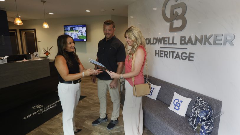 Coldwell Banker Heritage realtor Amy Braswell talks with Matt and Brynn Coy Friday, Aug. 9, 2024 at her office in Centerville. MARSHALL GORBY\STAFF