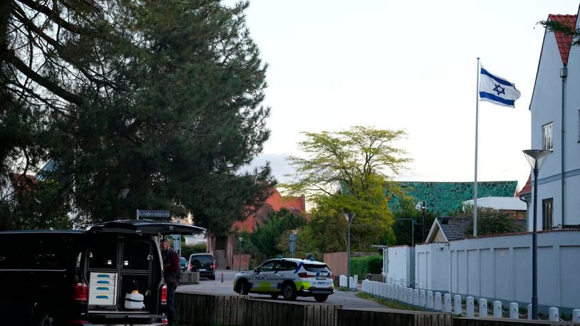 A police vehicle is seen near the Israeli embassy in Copenhagen, as police investigate two explosions near the site, on Wednesday, Oct. 2, 2024. (Emil Helms/Ritzau Scanpix via AP)