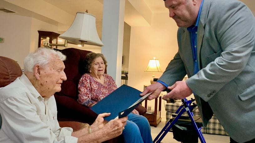 Sgt. Elmer Calvin Smith, left, receives a certificate of congratulations from Dan Diaspro, right, on Smith's 100th birthday, while his wife Elinora looks on. LONDON BISHOP/STAFF