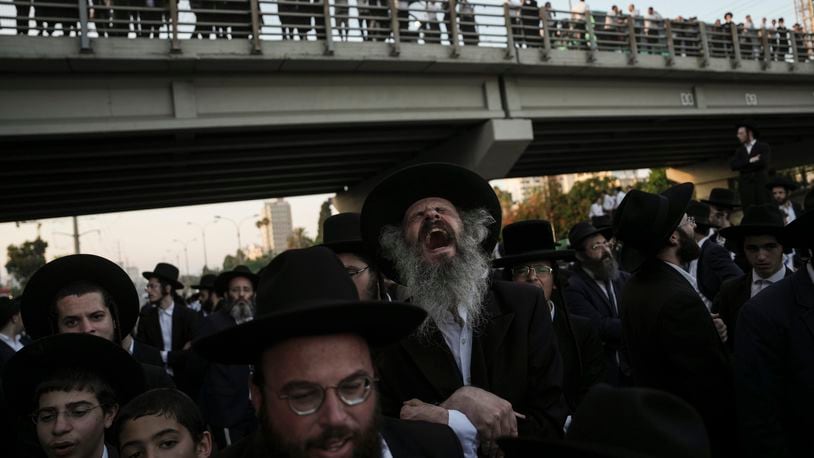Ultra-Orthodox Jewish men block a highway during a protest against army recruitment in Bnei Brak, Israel, Thursday, June 27, 2024. Israel's Supreme Court unanimously ordered the government to begin drafting ultra-Orthodox Jewish men into the army — a landmark ruling seeking to end a system that has allowed them to avoid enlistment into compulsory military service. (AP Photo/Oded Balilty)