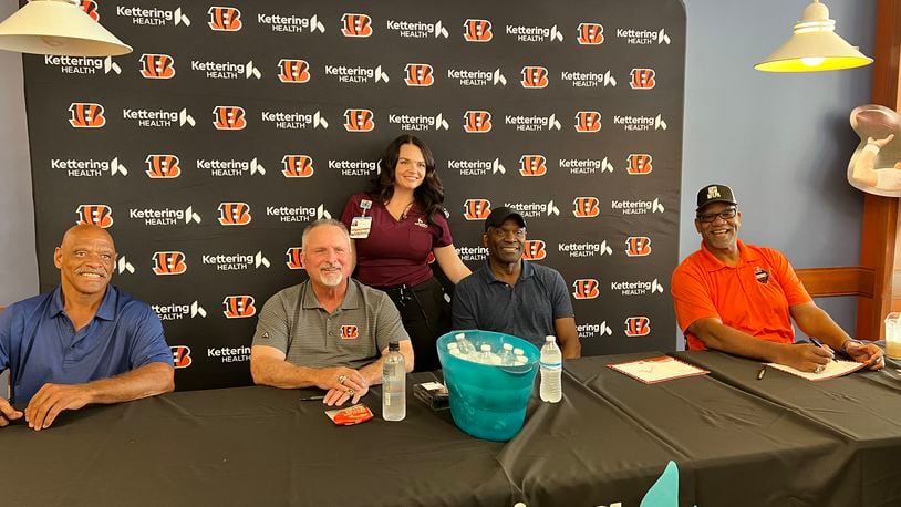 Retired NFL players visited Kettering Health Hamilton on Eaton Avenue on the city's west side to visit with staff and patients on Friday, Sept. 13, 2024, and sign some autographs. Posing with a hospital staff member are former Bengal Robert Jackson, former Bengal Jim Breech, former Bengal Louis Breeden, and former San Francisco 49er David Wilkins. CONTRIBUTED PHOTO/KETTERING HEALTH