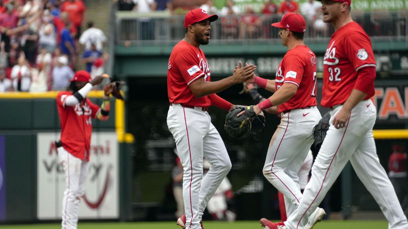 Cincinnati Reds' Jeimer Candelario, center, and Spencer Steer, second from right, celebrate following their team's 4-3 victory against the Chicago Cubs in a baseball game, Saturday, June 8, 2024, in Cincinnati. (AP Photo/Joshua A. Bickel)