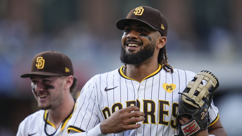 San Diego Padres right fielder Fernando Tatis Jr., right, jokes with teammate centerfielder Jackson Merrill during the seventh inning of a baseball game Monday, Sept. 2, 2024, in San Diego. (AP Photo/Gregory Bull)