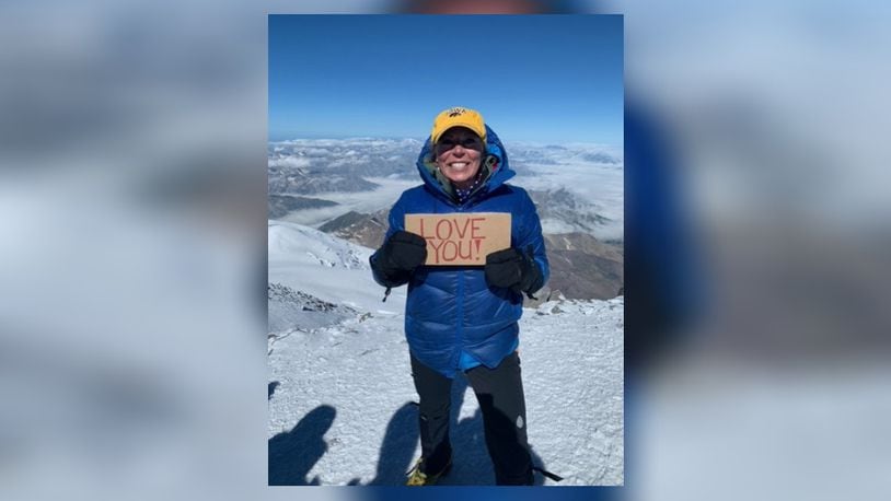 Cheryl Dillin, of Springboro, is a mountain climber. Here she shows off a "love you sign" and Iowa hat. CONTRIBUTED