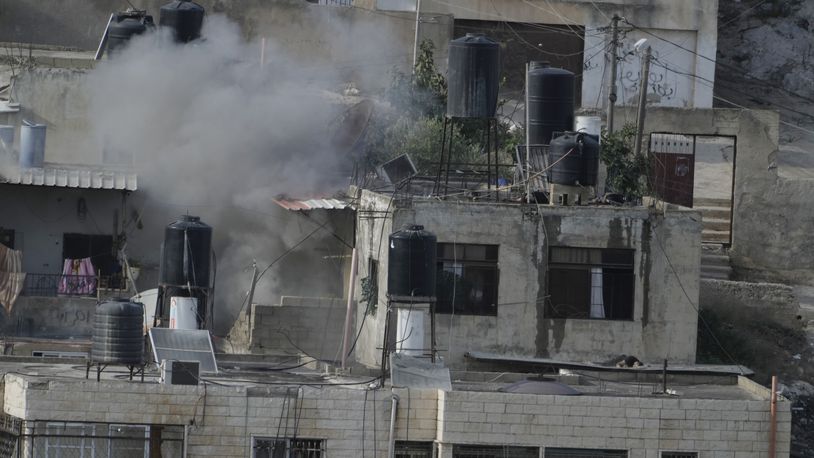 EDS NOTE: GRAPHIC CONTENT - An explosion is seen with three bodies lie motionless on rooftops in the West Bank town of Qatabiya during a raid, Thursday, Sept. 19, 2024. (AP Photo/Majdi Mohammed)