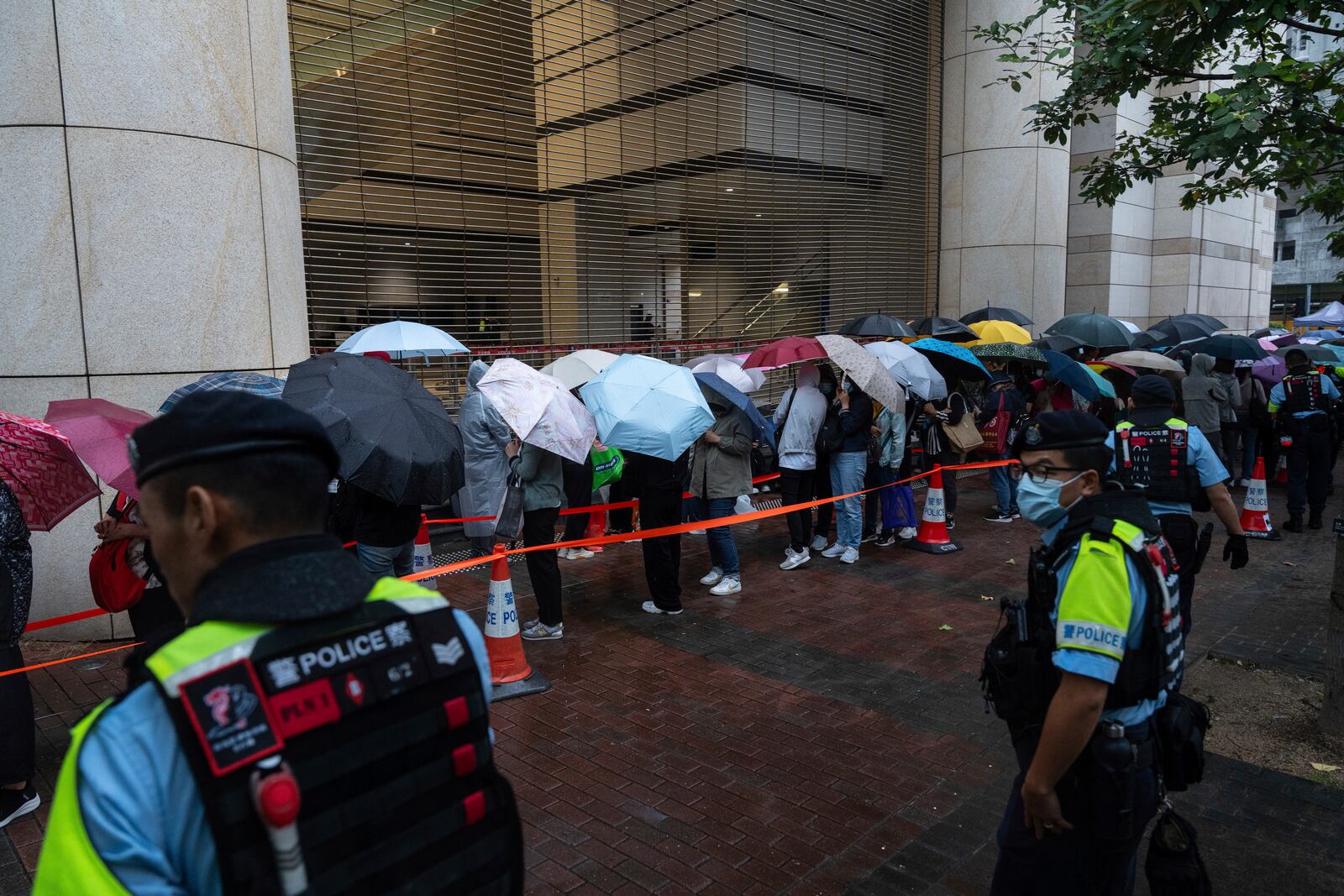 People wait outside the West Kowloon Magistrates' Courts in Hong Kong Tuesday, Nov. 19, 2024, ahead of the sentencing in national security case. (AP Photo/Chan Long Hei)