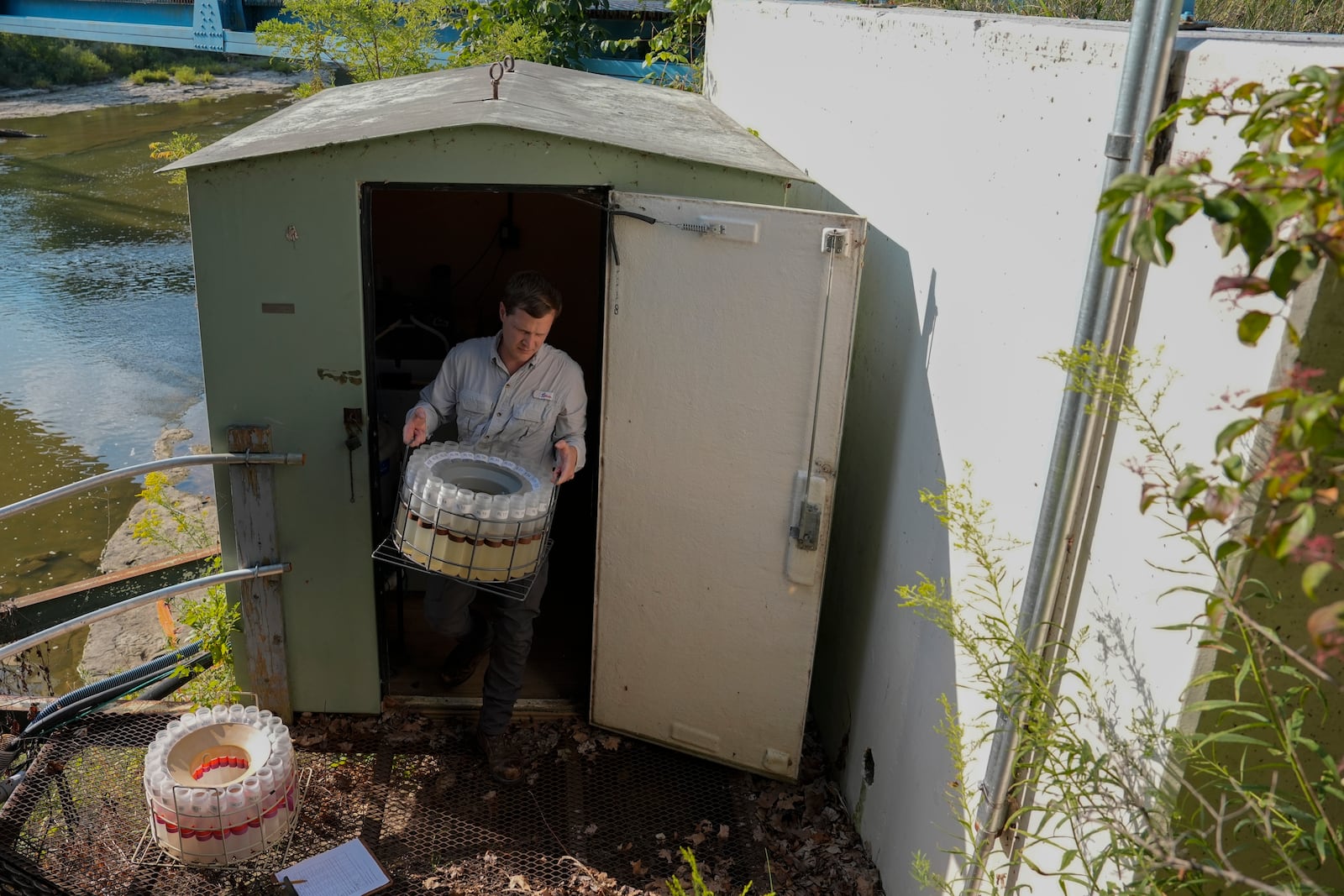 Jake Boehler, field manager at the National Center for Water Quality Research, collects water samples from a monitoring station along the Sandusky River, Monday, Aug. 26, 2024, in Fremont, Ohio. (AP Photo/Joshua A. Bickel)