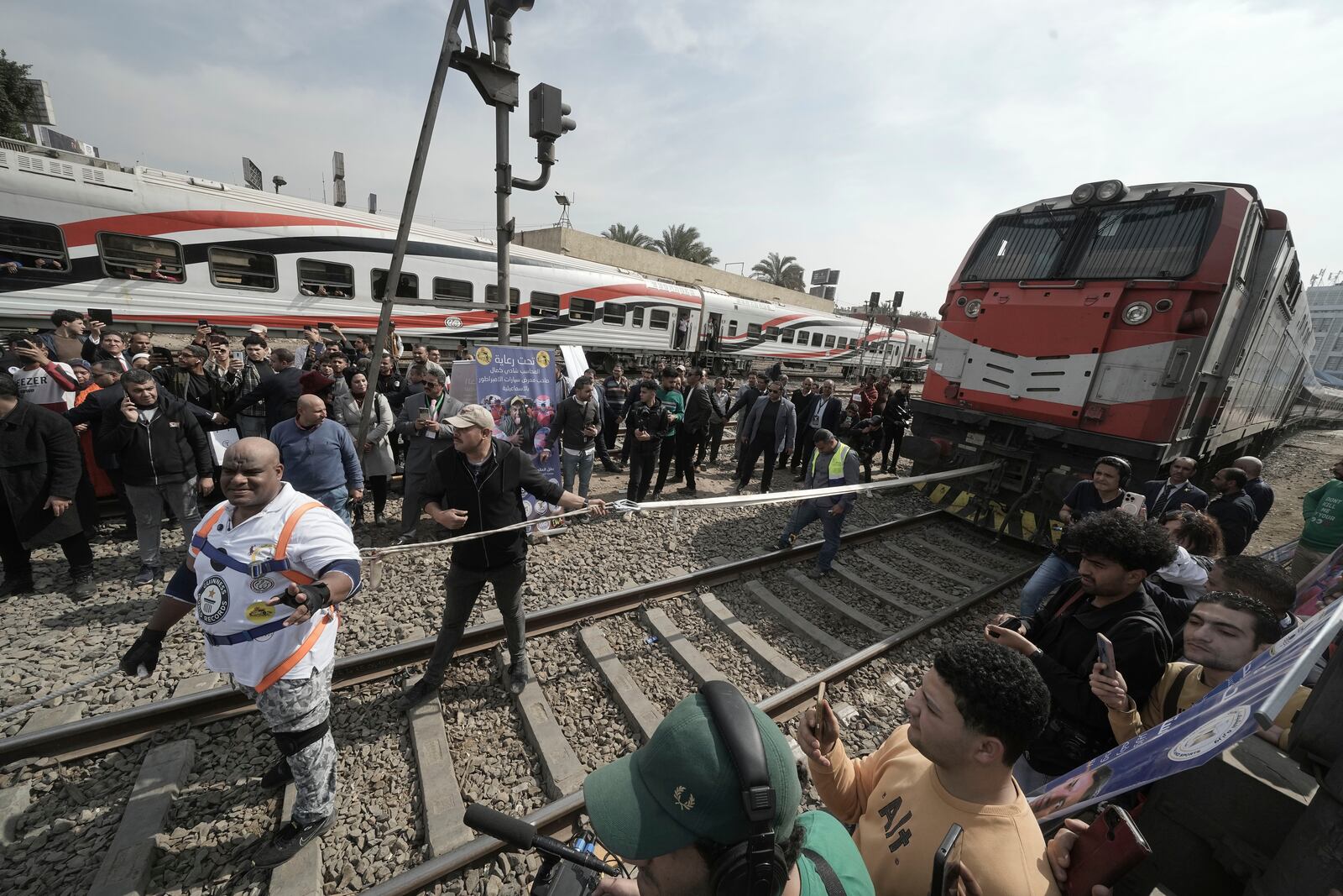 Egyptian wrestler Ashraf Mahrous, front left, better known as Kabonga, prepares to pull a train for nearly 10 meters, 33 feet, at Ramses Station in Cairo, Egypt, Thursday, March 13, 2025. (AP Photo/Amr Nabil)