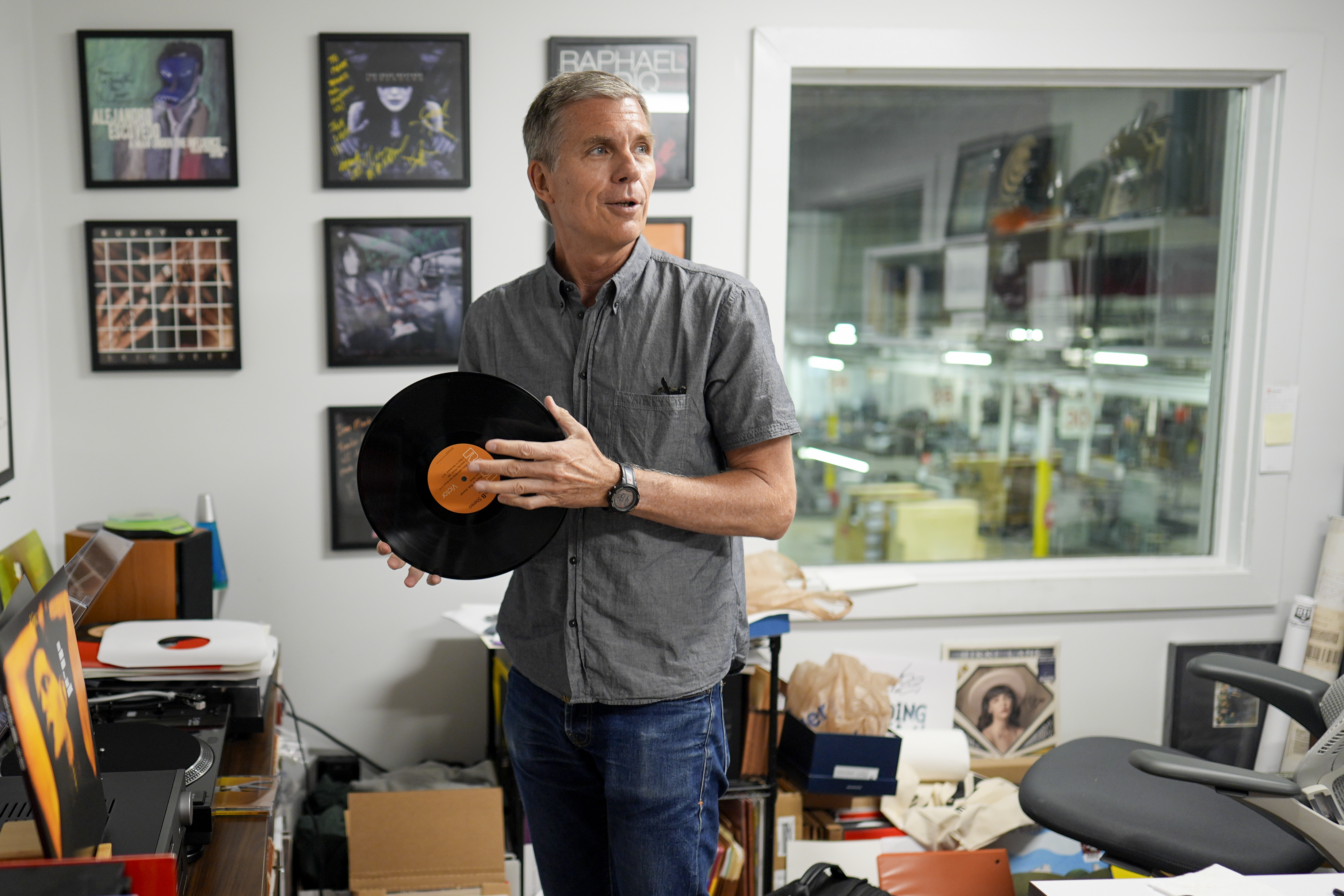 Mark Michaels, CEO & Chairman of United Record Pressing, hold a vinyl recored in his office July 11, 2024, in Nashville, Tenn. (AP Photo/George Walker IV)