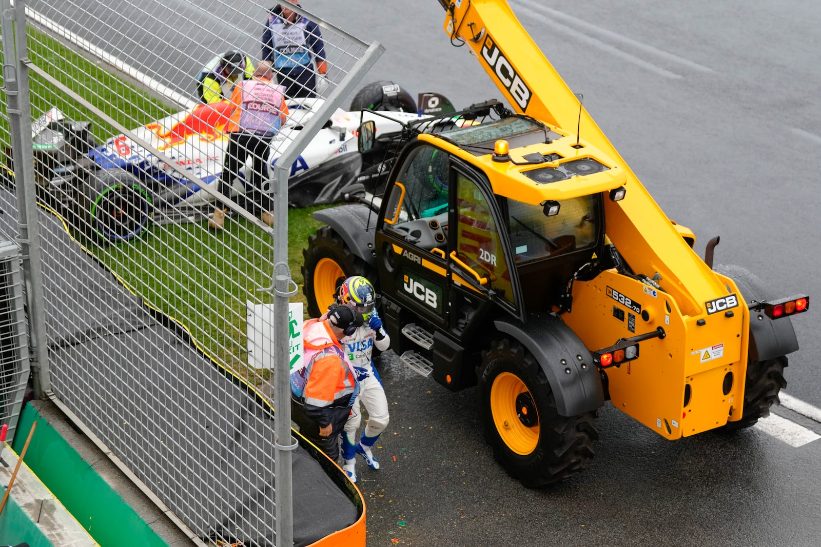 Team RB driver Isack Hadjar of France is assisted by a track marshal after his car hit a wall on the formation lap ahead of the Australian Formula One Grand Prix at Albert Park, in Melbourne, Australia, Sunday, March 16, 2025. (AP Photo/Asanka Brendon Ratnayake)