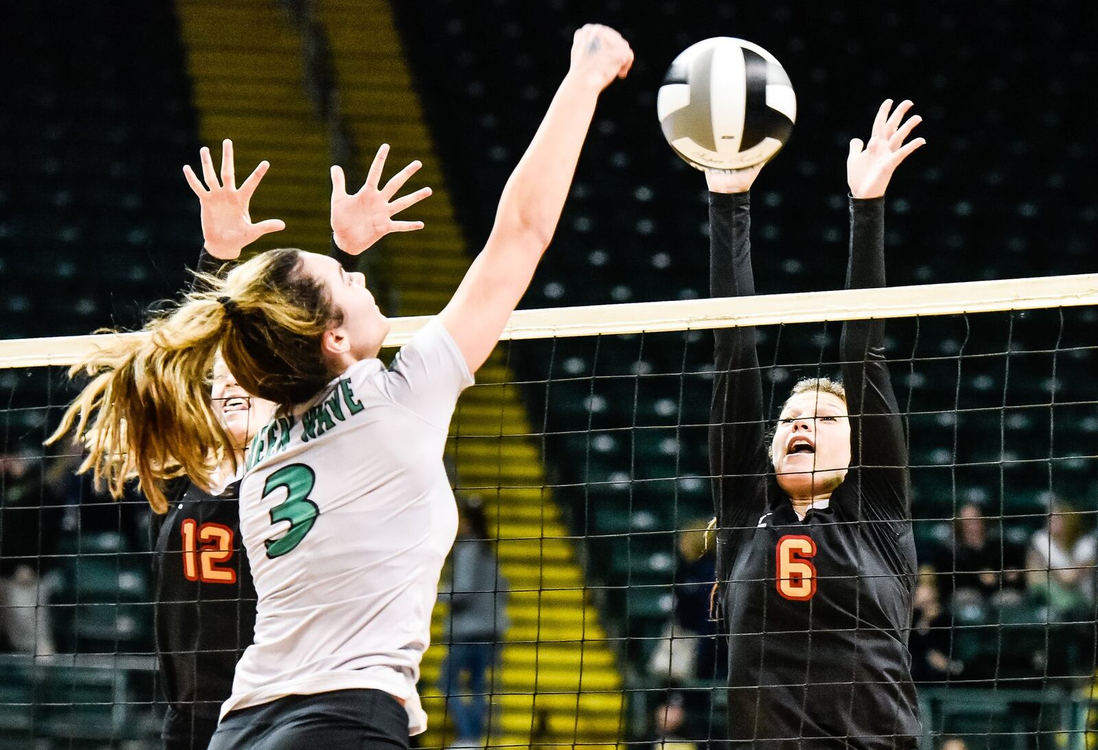 Fenwick’s Grace Dinkelaker (6) and Kate Hafer (12) go up for a block attempt on Parma Heights Holy Name’s Samantha Snow during Friday’s Division II state volleyball semifinal at Wright State University’s Nutter Center. NICK GRAHAM/STAFF