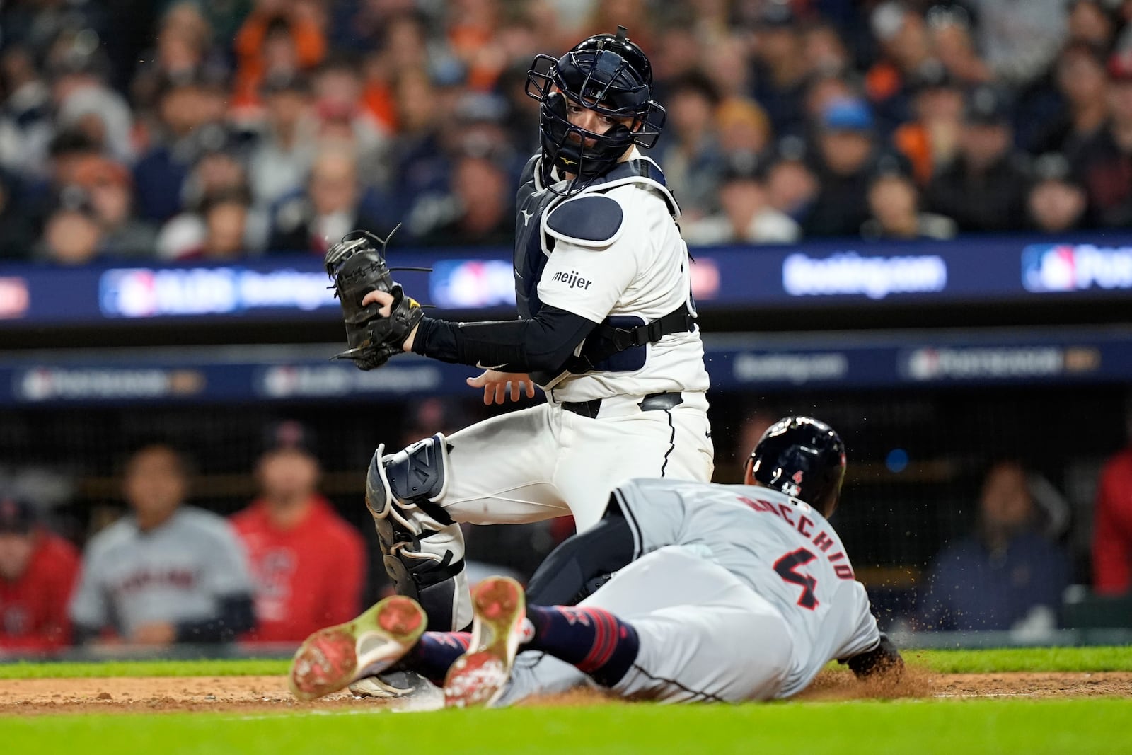 Cleveland Guardians' Brayan Rocchio, right, scores in front of Detroit Tigers catcher Jake Rogers, left, on a bunt by David Fry in the eighth inning of Game 4 of a baseball American League Division Series, Thursday, Oct. 10, 2024, in Detroit. (AP Photo/Carlos Osorio)