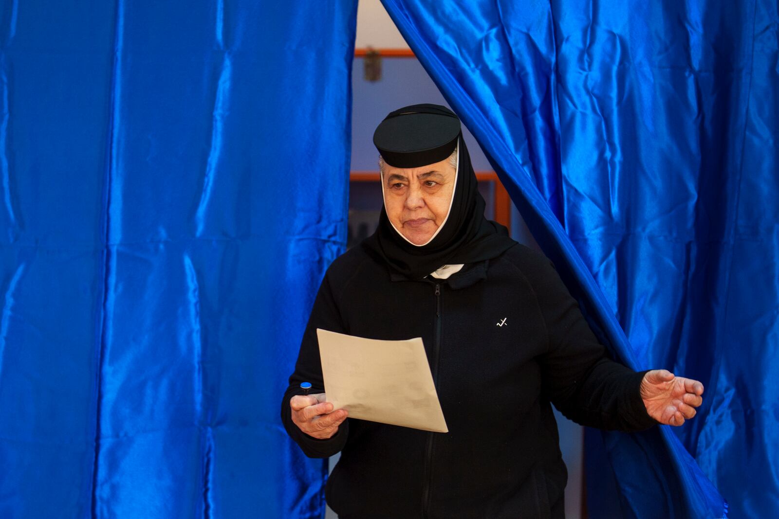 An Orthodox nun exits a cabin after voting in the country's presidential elections, in Pasarea, Romania, Sunday, Nov. 24, 2024. (AP Photo/Vadim Ghirda)