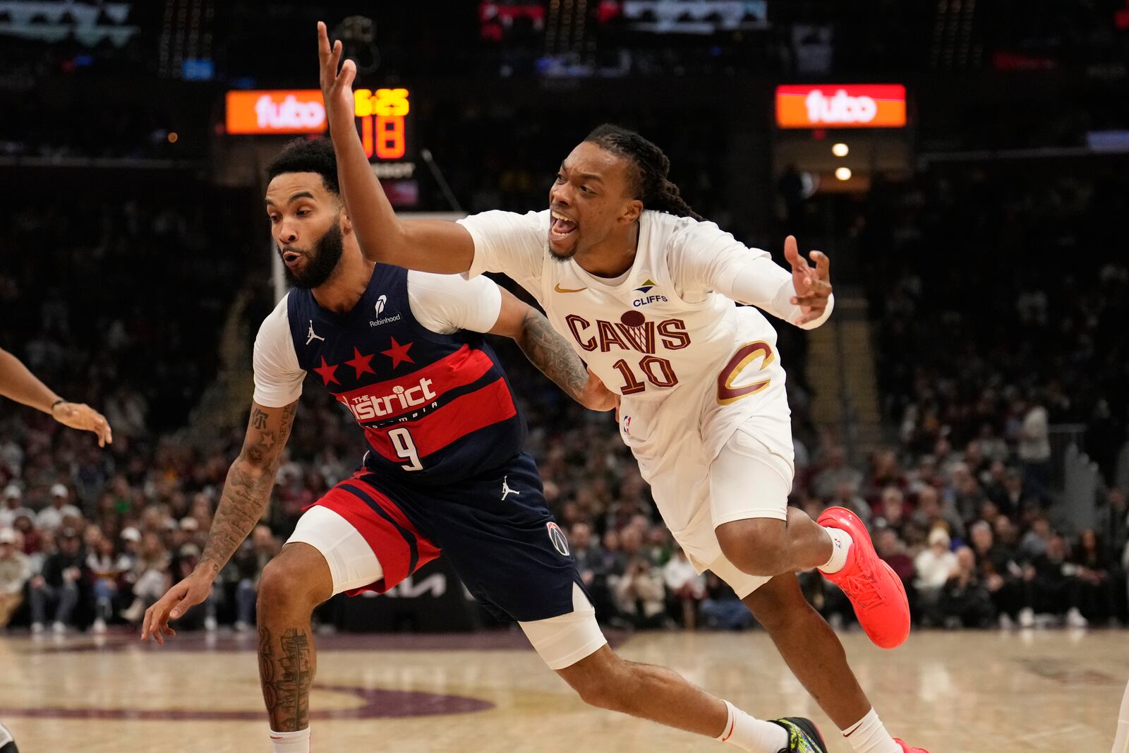 Cleveland Cavaliers guard Darius Garland (10) reacts after being striped of the ball and fouled by Anthony Gill, not in the photo, in the first half of an NBA basketball game, Friday, Dec. 13, 2024, in Cleveland. Wizards Justin Champagnie (9) is at left. (AP Photo/Sue Ogrocki)