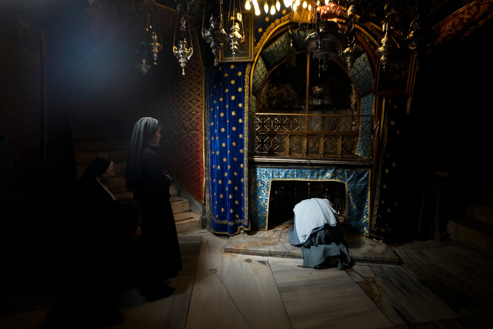 Worshippers pray at the Church of the Nativity, traditionally believed to be the birthplace of Jesus, on Christmas Eve, in the West Bank city of Bethlehem, Tuesday, Dec. 24, 2024. (AP Photo/Matias Delacroix)