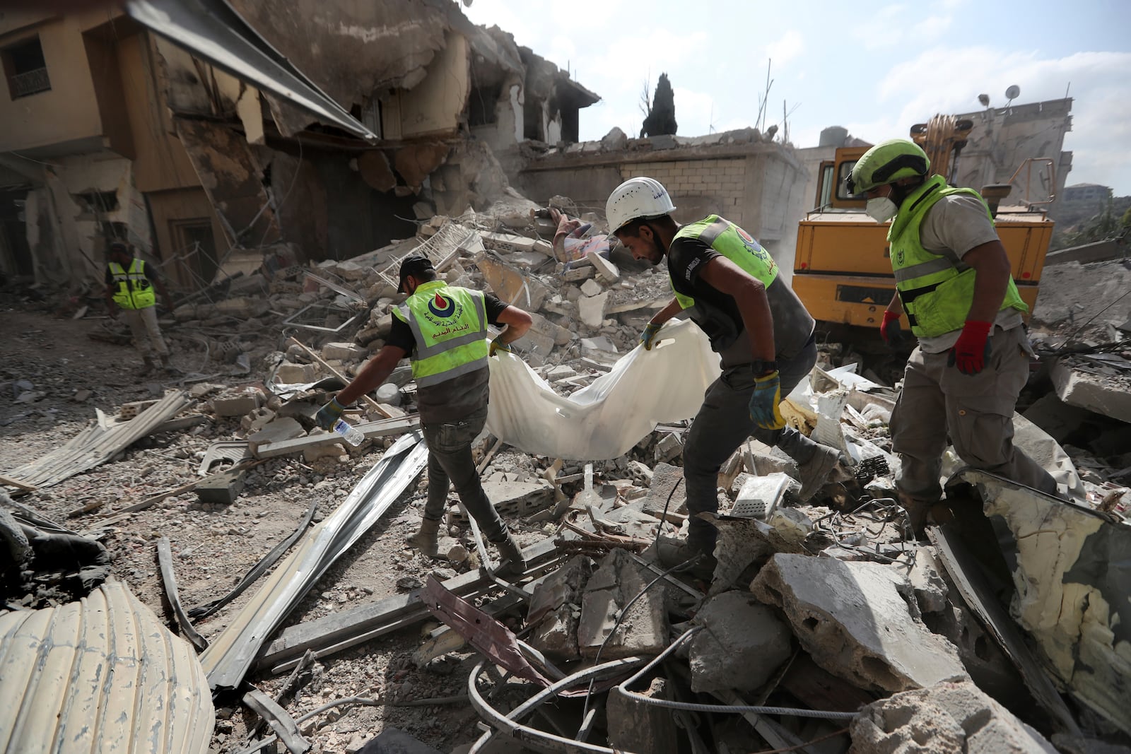 Rescue workers carry remains of killed people at the site that was hit by Israeli airstrikes in Qana village, south Lebanon, Wednesday, Oct. 16, 2024. (AP Photo/Mohammed Zaatari)