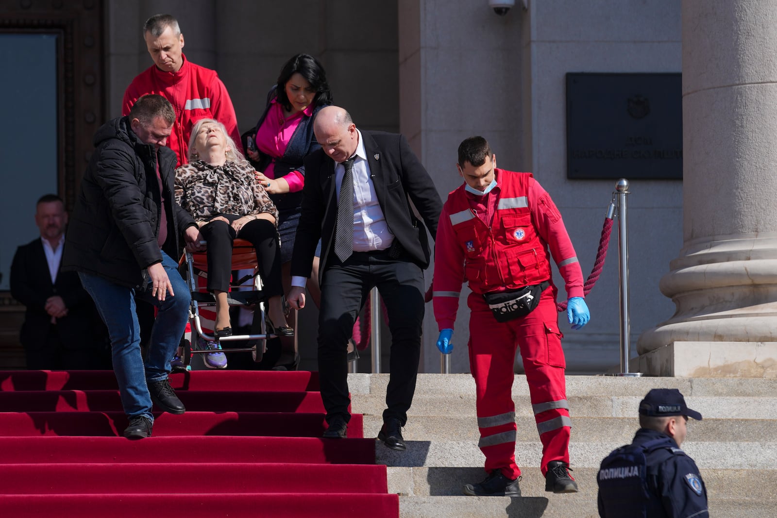 Medics carry a lawmaker injured after chaos erupted during a parliament session in Belgrade, Serbia, Tuesday, March 4, 2025. (AP Photo/Darko Vojinovic)